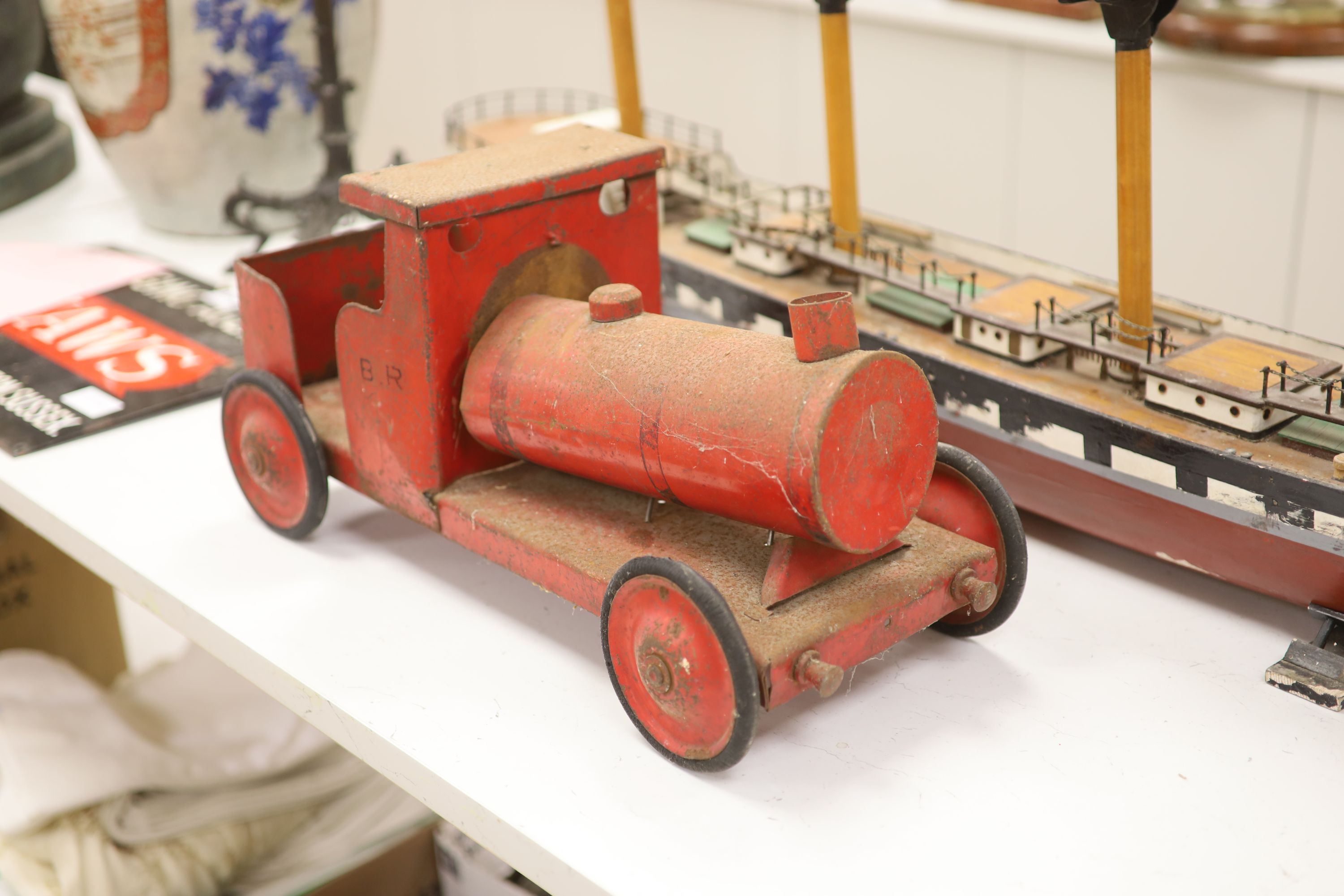 A scratch built primitive model of a cutter and an enamelled metal model of a locomotive, longest 137cm